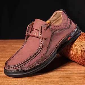 Detailed view of handmade stitching and breathable perforations on a brown leather loafer.