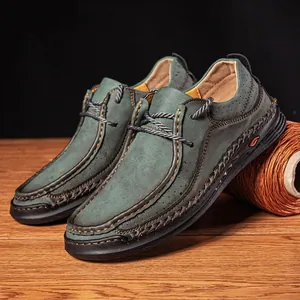 Detailed close-up of handmade stitching and premium texture on dark green leather loafers