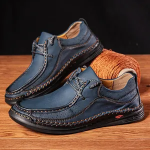Detailed close-up of handmade navy blue leather driving shoes featuring contrast stitching