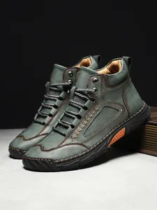 Eleganti stivaletti da uomo in pelle verde con cuciture a contrasto decorative