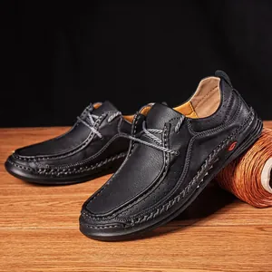 Detailed view of handmade black leather loafers with breathable holes and contrast stitching
