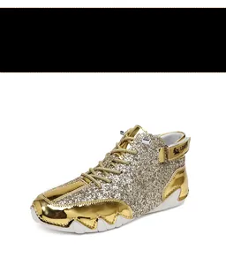 Detailed view of gold sequined high-top boots with metallic panels and jagged sole