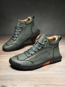 Robusti stivaletti in pelle verde per uomo con cuciture e design stringato classico