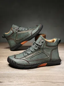 Stivaletti vintage da uomo in pelle grigio-verde con cuciture e suola resistente.