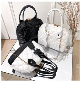 Elegant quilted shell handbags in black and white displayed on a mirror surface.