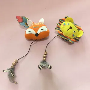 Détail des jouets en peluche pour chat avec motifs renard et lion mignons et plumes.