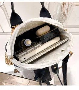 Detailed view showing the spacious interior and capacity of a white quilted shell handbag.