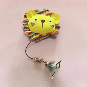 Détail d'un mignon jouet pour chat en peluche lion avec cordon élastique et plumes