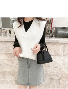Stylish black quilted shell handbag held by a model in a modern cafe lifestyle setting