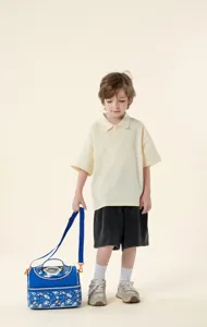 Child model holding a blue cartoon astronaut insulated lunch bag with shoulder strap
