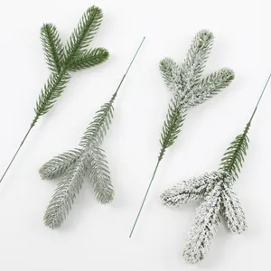 Close-up detail of artificial PE pine needles with snow effect for Christmas DIY decoration.