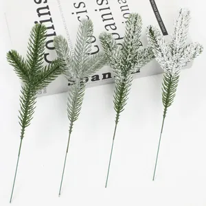 Detailed view of four artificial PE pine needles with varying artificial snow levels.