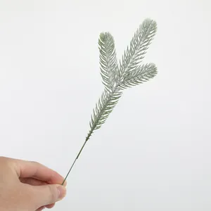 Detail view of artificial three-pronged pine branch with frosted snow for DIY Christmas decor