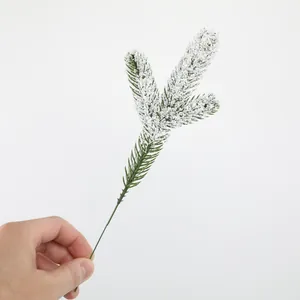 Close-up of artificial pine branch with realistic snow flocking for DIY decor