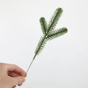 Macro detail of a green artificial three-pronged pine branch for Christmas DIY decor