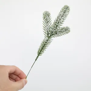 Detail view of artificial PE pine needle branch with fake snow for DIY Christmas decoration