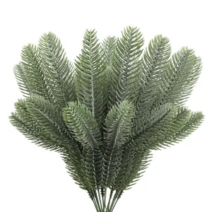 Macro view of artificial PE pine needle branches with realistic snow frost for Christmas DIY