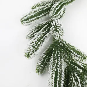 Close-up of frosted artificial pine branch with realistic snow flocking for DIY décor