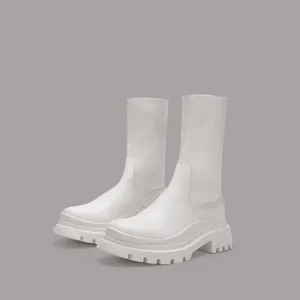 Close-up detail of white platform mid-calf stretch boots with thick treaded soles