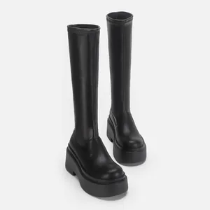 Schicke schwarze kniehohe Stretchstiefel mit klobiger Plateausohle für mehr Größe