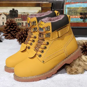 Primer plano de botas de trabajo de cuero amarillo con forro de piel y suela de goma
