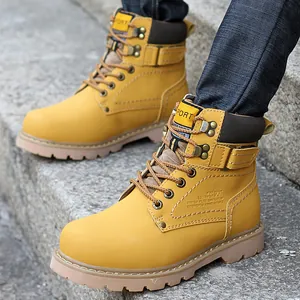 Primer plano de botas de trabajo de cuero amarillo duraderas con suelas antideslizantes.