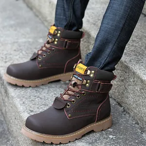 Primer plano de botas de trabajo de cuero marrón para hombre en escalones de piedra.