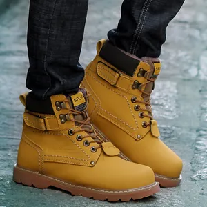 Primer plano de botas de trabajo clásicas de cuero amarillo para hombre con cordones duraderos.