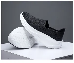 Primer plano de zapatos negros tejidos a mano con suelas blancas gruesas y relieve.