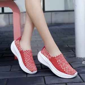 Zapatos de plataforma tejida rojos ligeros para mujer en un entorno de exterior