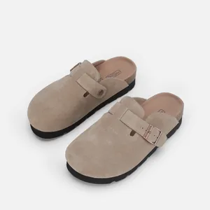 Détail des sabots en daim taupe avec semelle en liège et boucle métallique réglable