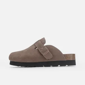 Vue latérale de sabots en daim marron avec boucle réglable et semelle en liège