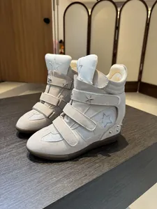 Side view of beige wedge high-top sneakers with velcro straps and star detail