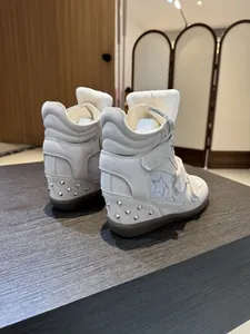Rear view of high-top wedge sneakers with velcro straps and studded heel detail