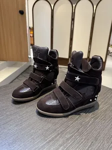 Detailed macro view of dark brown suede high-top wedge sneakers with silver star studs