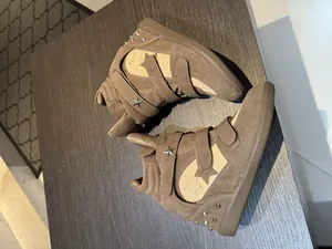 Macro view of brown suede wedge sneakers with multi-strap velcro and star stud details