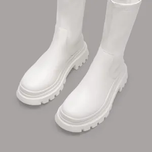 White chunky platform mid-calf stretch boots shown in a minimalist grey studio setting