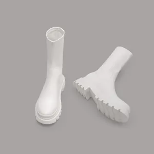 Detailed view of white platform stretch ankle boots featuring chunky treaded rubber soles