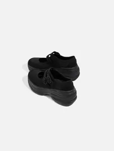 Close-up of black platform Mary Jane shoes with double buckle straps and thick sole