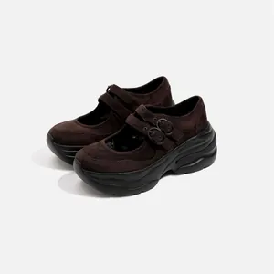 Detailed side view of dark brown suede platform Mary Jane shoes with double buckle straps