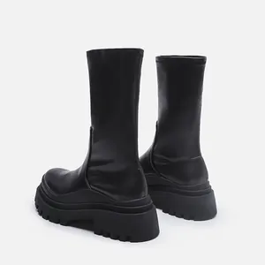 Rear view detail showing the chunky lug sole of black platform mid-calf stretch boots