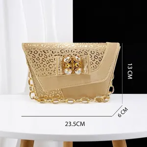 Detailed view of an asymmetrical gold leopard print evening bag with rhinestone bow