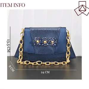 Pochette da sera blu motivo serpente con fiori di cristallo e catena dorata spessa