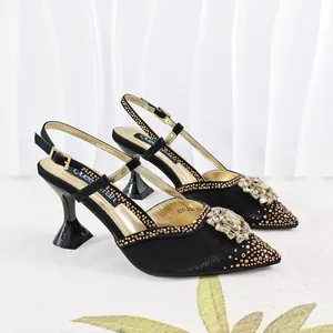 Close-up of black satin pointed-toe sandals featuring sparkling rhinestone floral accents