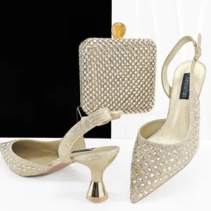 Elegante conjunto de tacones de aguja dorados con strass y bolso de noche a juego para gala