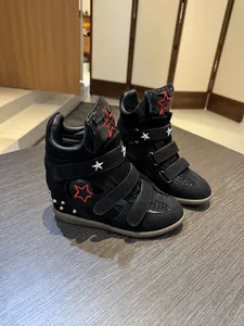Detailed view of women's black high-top wedge sneakers with stars and velcro straps