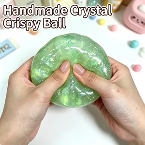 Detailed view of hands squeezing a green translucent glittery crispy stress relief toy