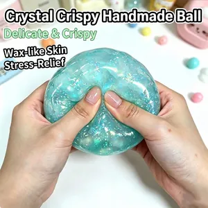 Detail macro shot of hands squeezing a glittery blue crystal clay crispy squishy toy