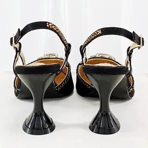 Rear view detail of black evening sandals with unique flared trumpet heels and crystals