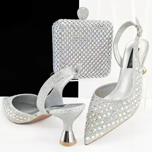Elegantes tacones destalonados de color plateado con pedrería y bolso de mano a juego.